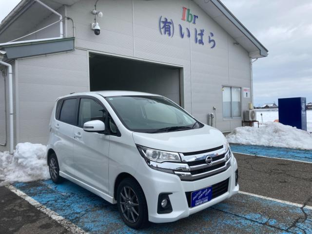 雪の残る店の前に停めた白い軽自動車